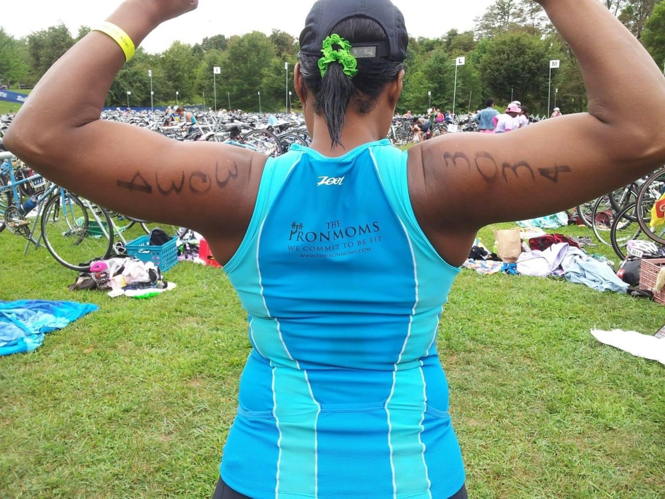 image of a woman with her back to the camera flexing her biceps with writing written on the back of her arms 