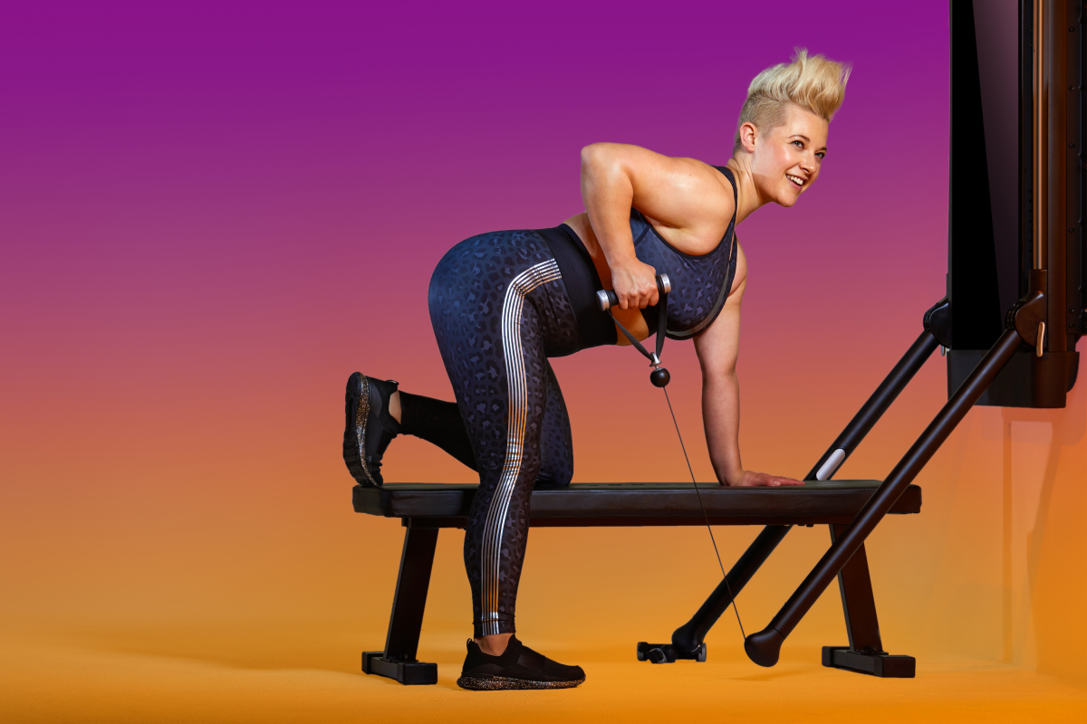 woman doing a single arm bent over row on Tonal to illustrate hiking exercises