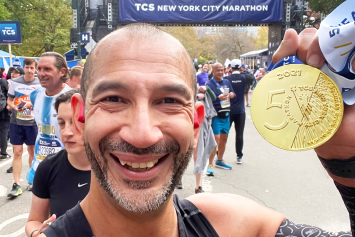 Eric Castro showing his NYC Marathon medal 