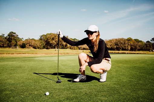 golf tips for advanced golfers: pro woman on the range with her club and tee