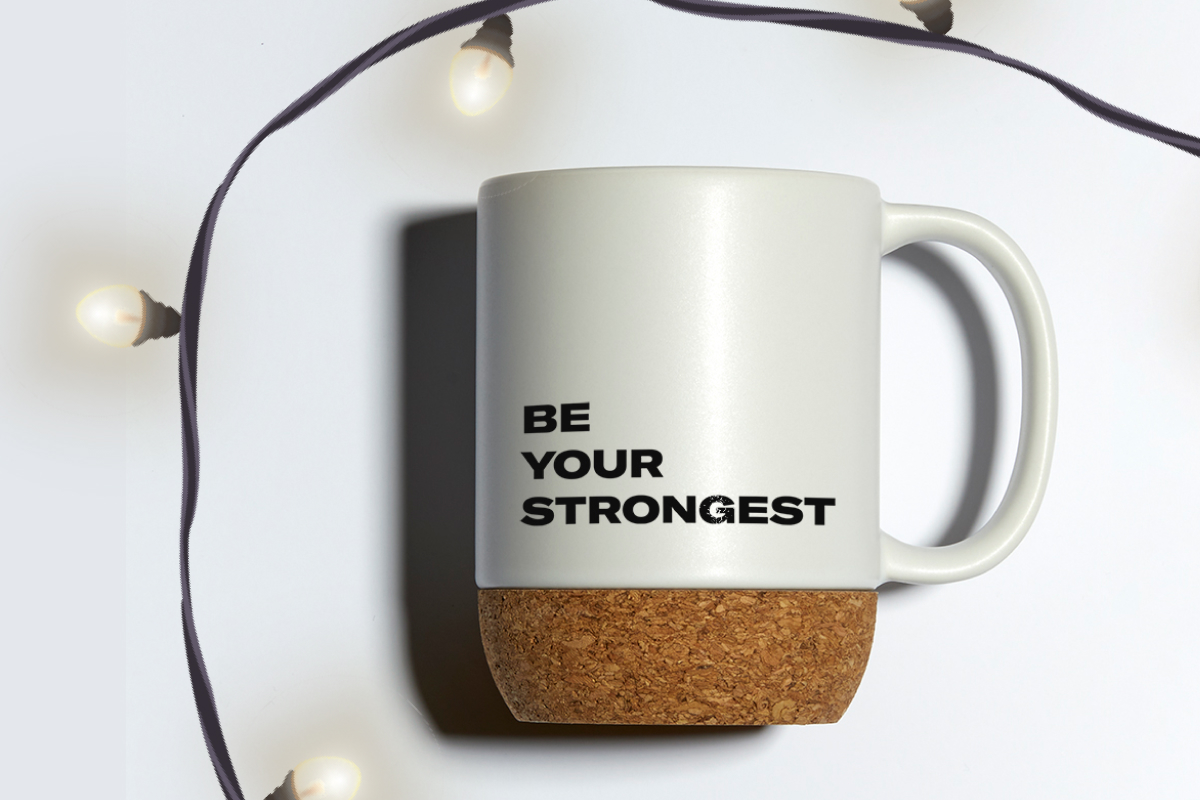a white thermal portable mug with Be Your Strongest written on it