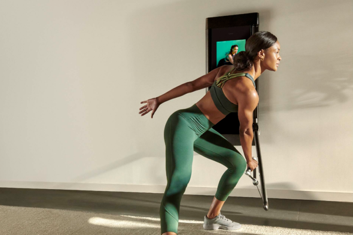 a woman working out on Tonal doing a side lunge