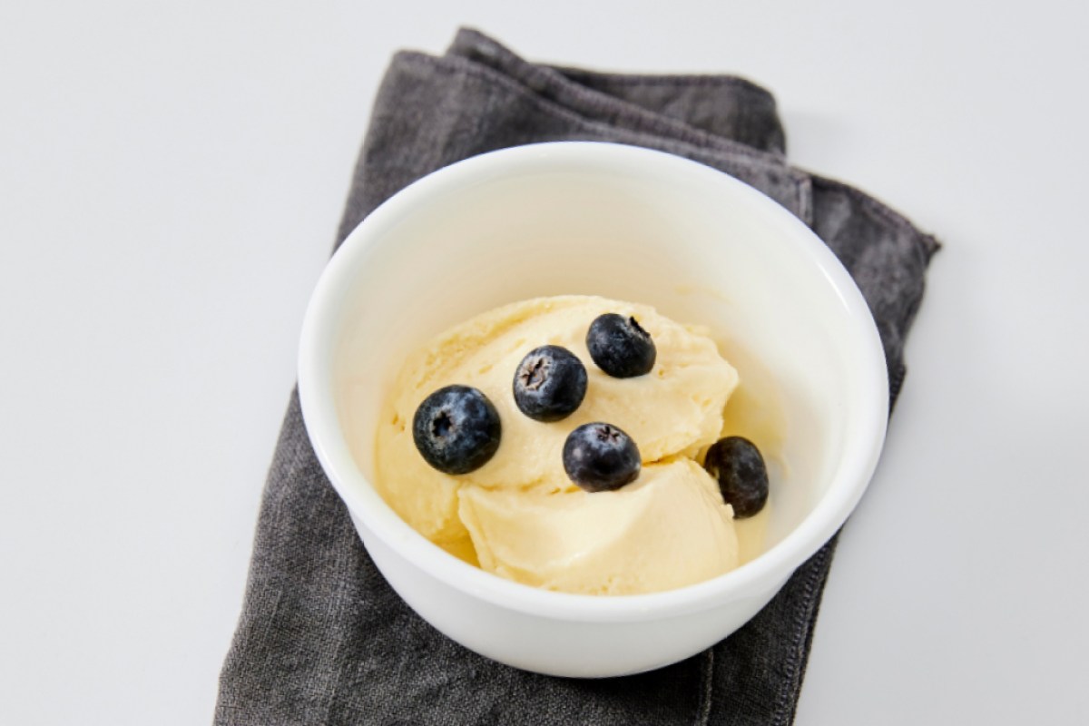 a bowl of frozen mango yogurt with blueberries