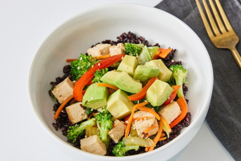 a bowl with tofu, rice and colorful veggies in it