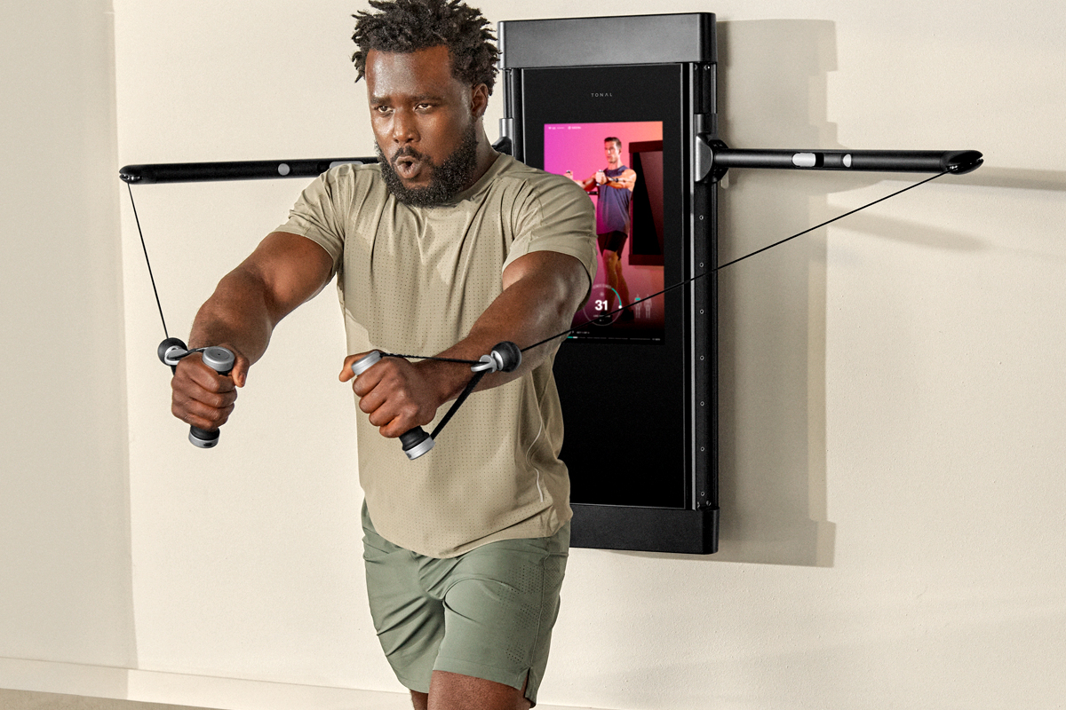 Image of a man performing a chest fly exercise on the Tonal trainer.