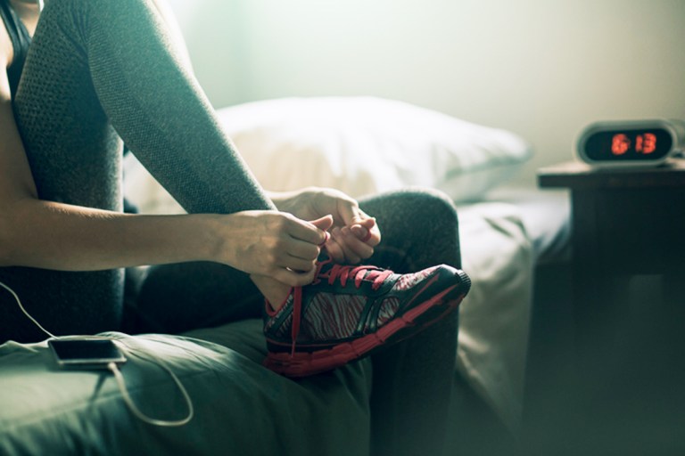 Image of someone tying their sneakers in the early morning for goal setting.