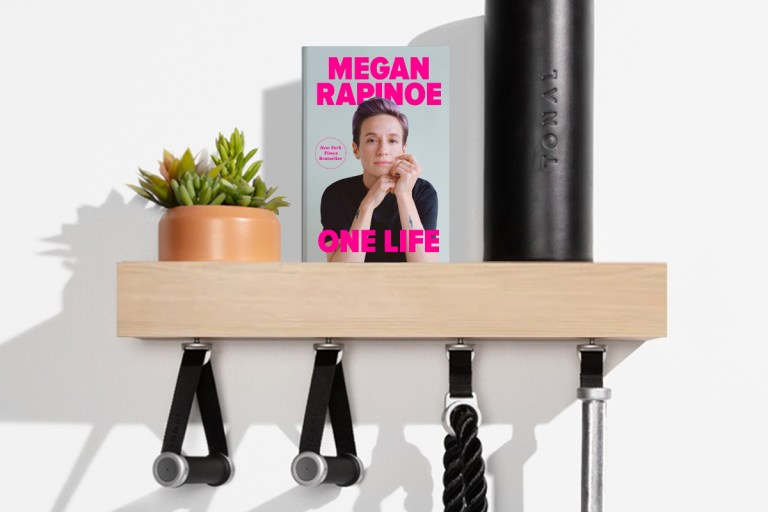 One Life by Megan Rapinoe book cover on a shelf with Tonal accessories