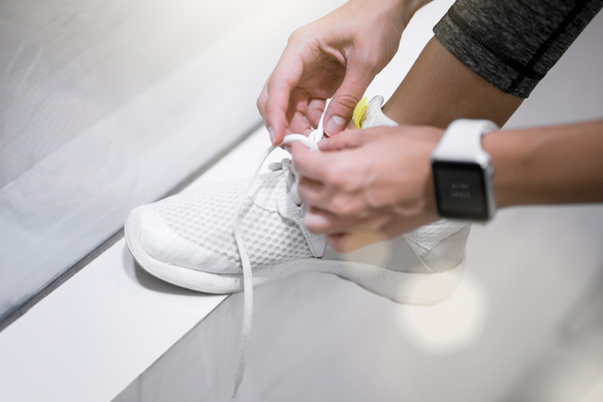 How to start exercising again. Close-up of a woman lacing up her sneaker. 