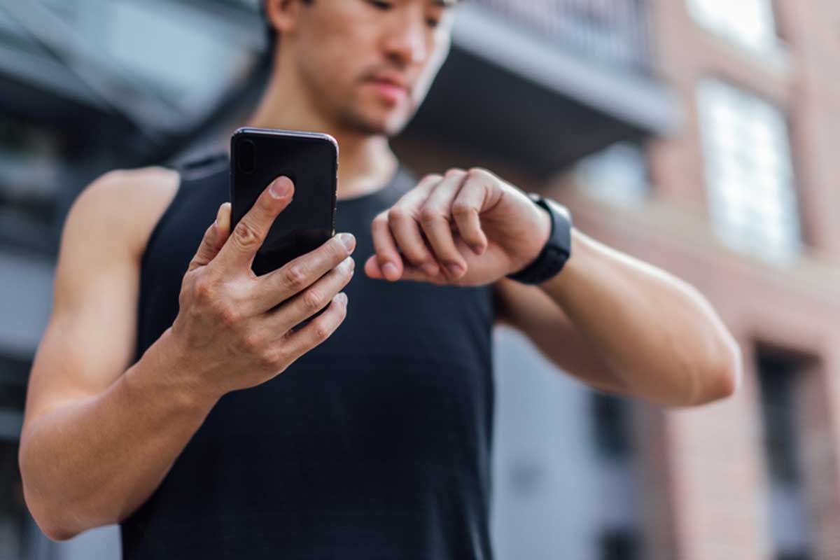 Man in fitness gear looking at his smart watch.