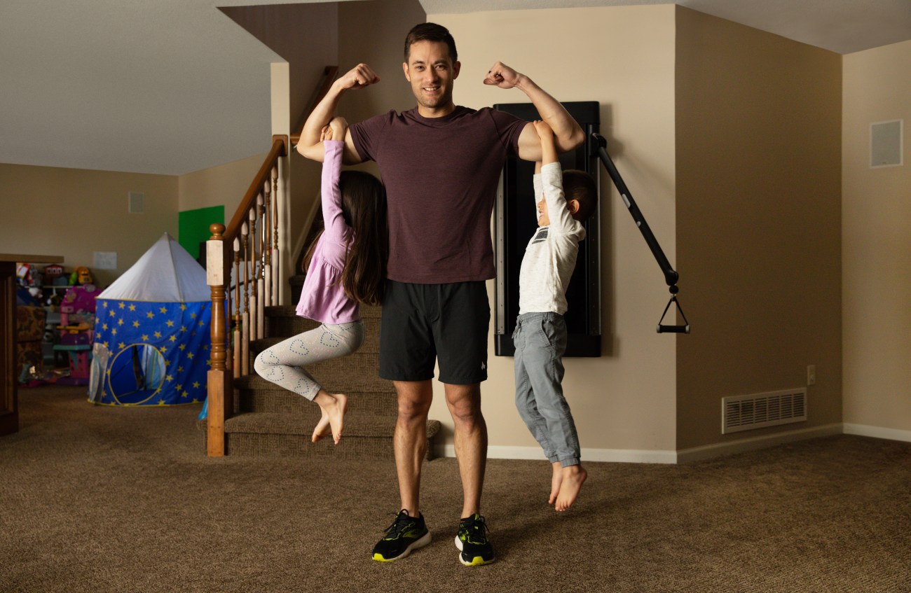 John Sill lifting up his kids on his biceps.